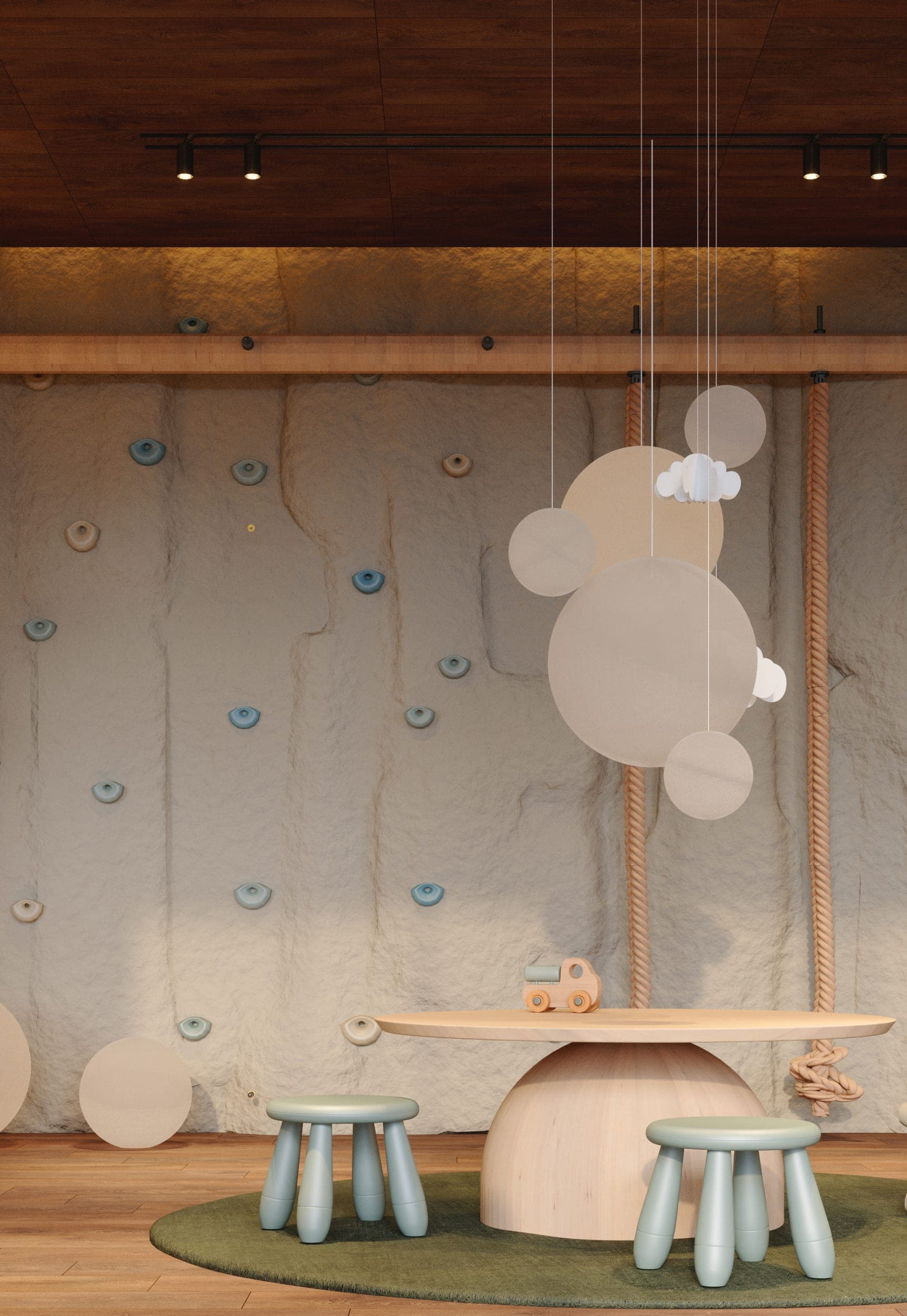 Hotel Peștera children's playroom: climbing wall, cloud mobile and small stools on a green rug