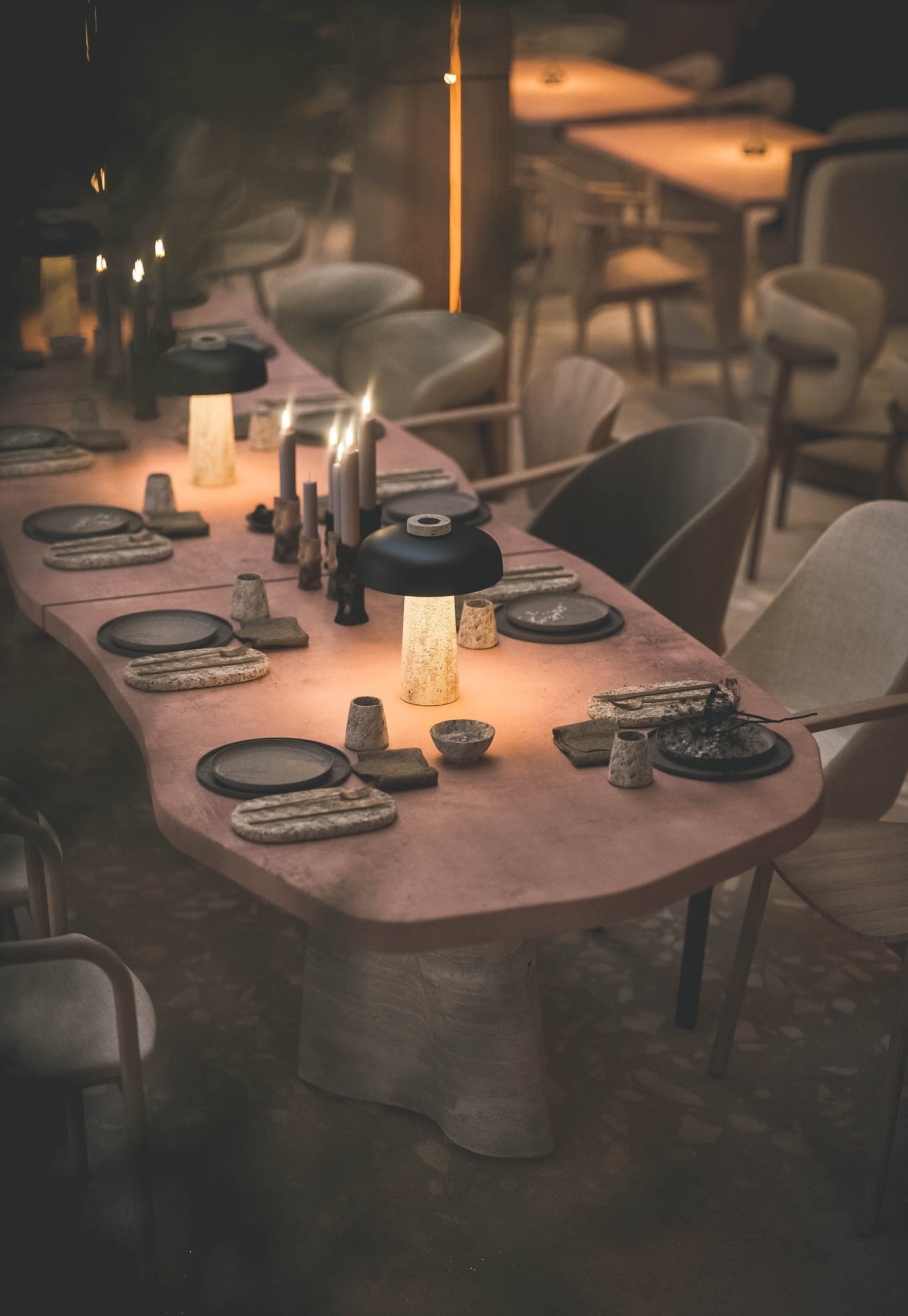 Bosco: long pink stone table laid by candlelight
