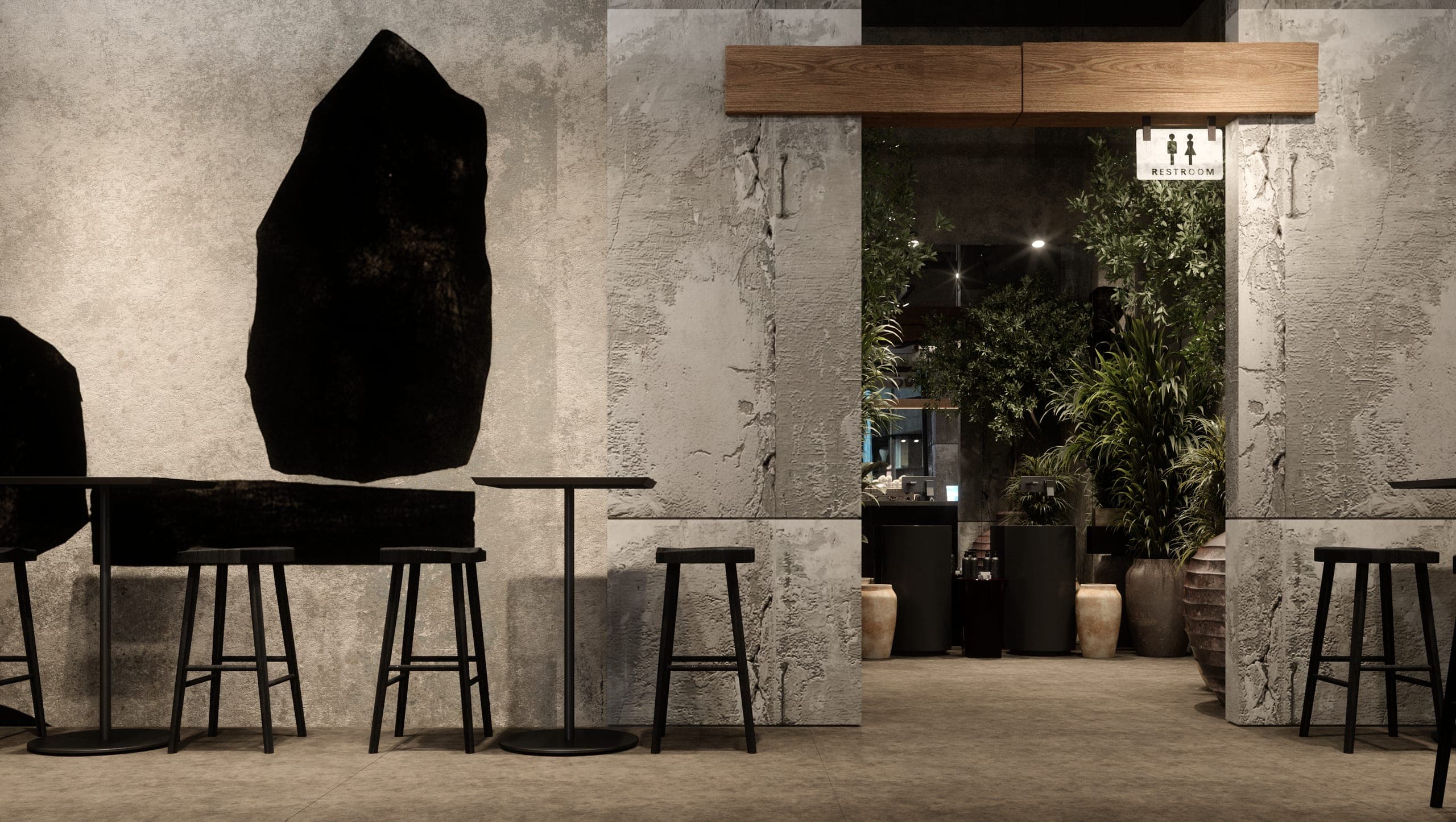 KAVO: high tables and stools beside black stone-like wall pieces, with a planted passage beyond