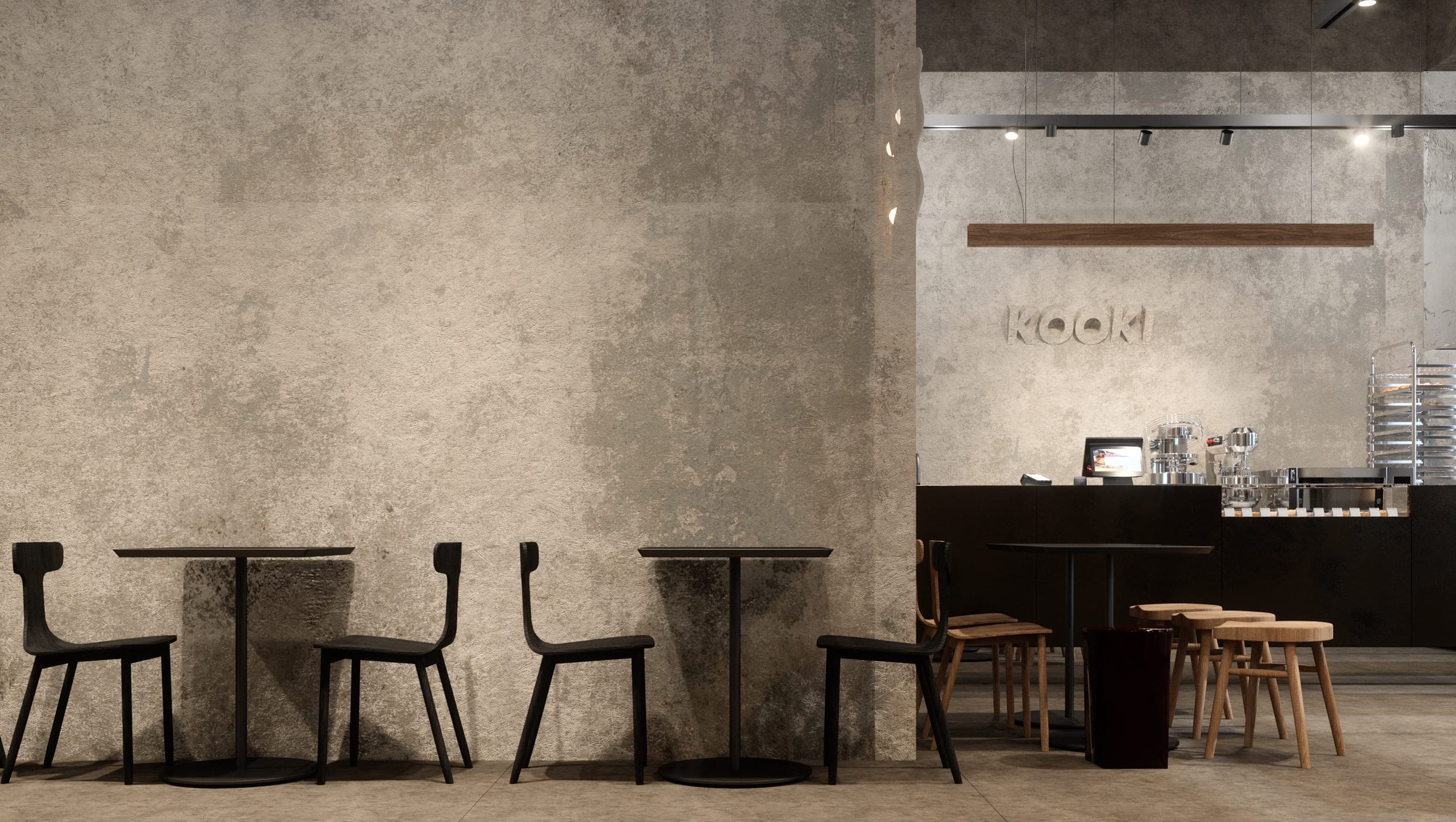 KAVO: tables for two along a raw concrete wall, the counter beyond