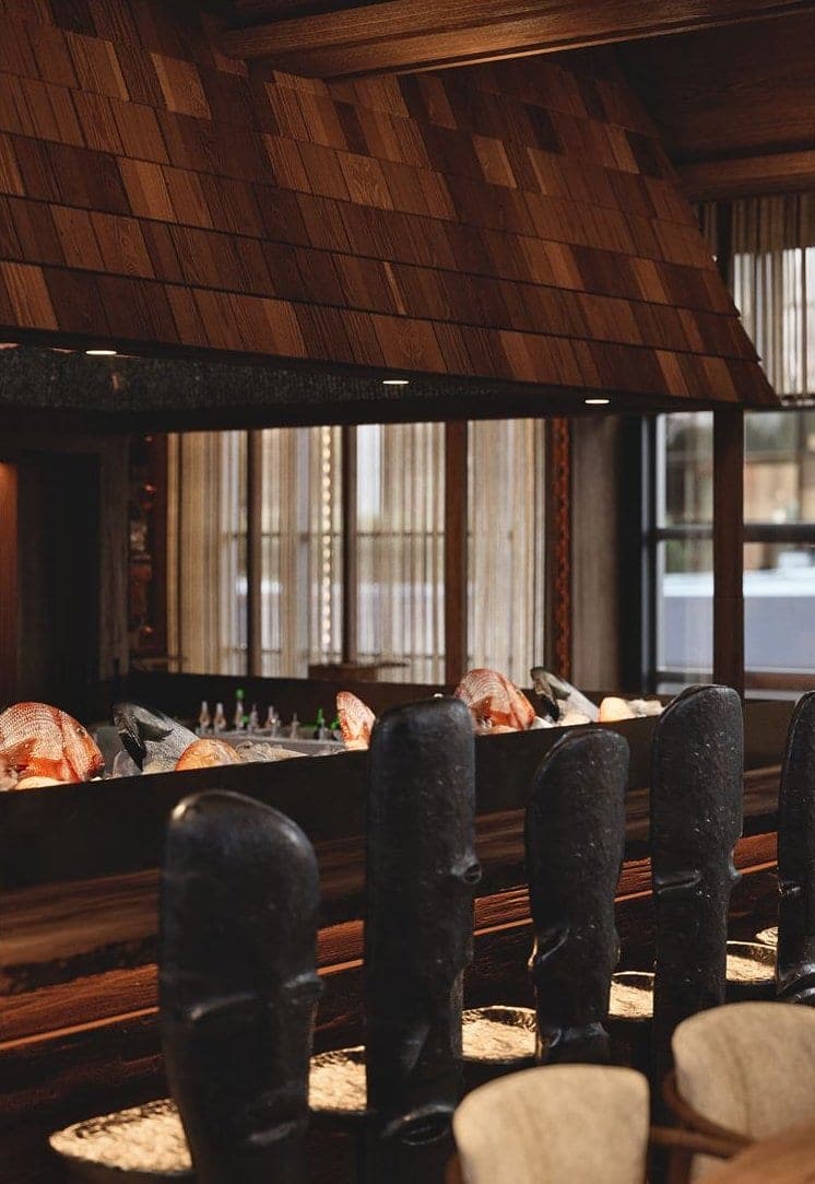 Bamboomat: bar counter with carved stools beneath the shingled canopy